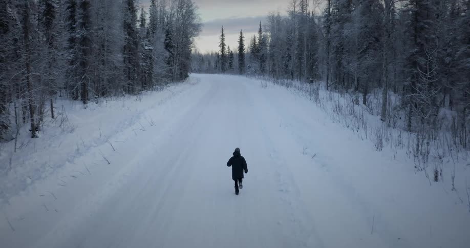 A person running on the snowcovered road during winter