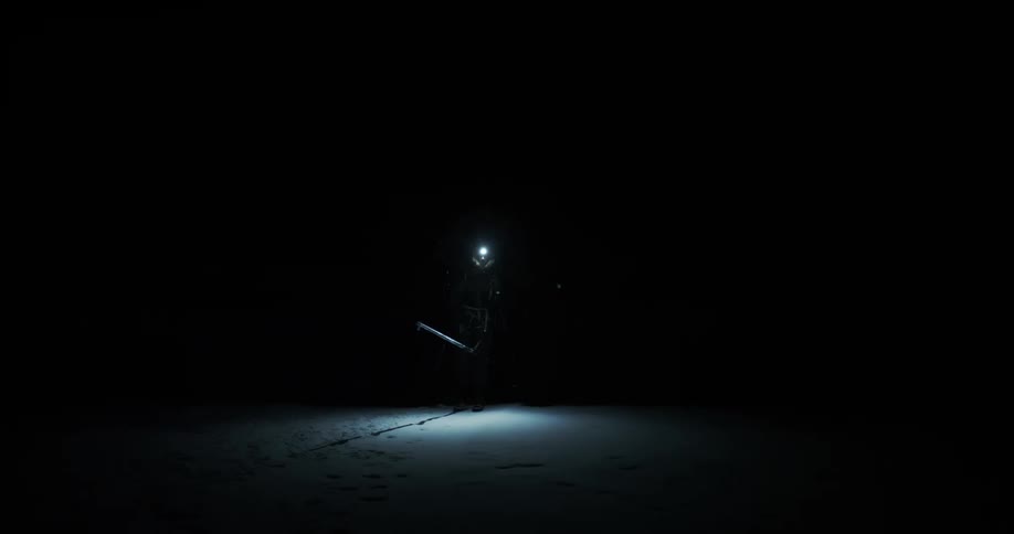 A person is hiking in the snow at night