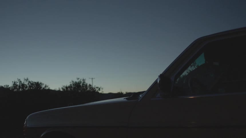 Vehicle sitting in a desolate area at sunset