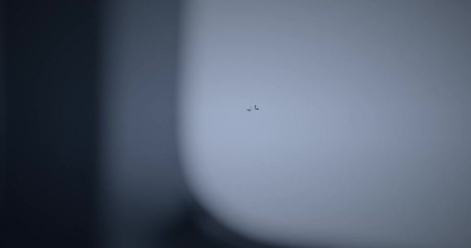 Aircraft passes person traveling down snow covered mountain slope in winter