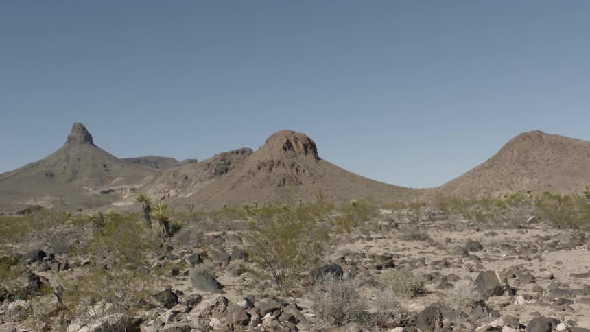 A scenery of a few big hills like mountains on a sunny day