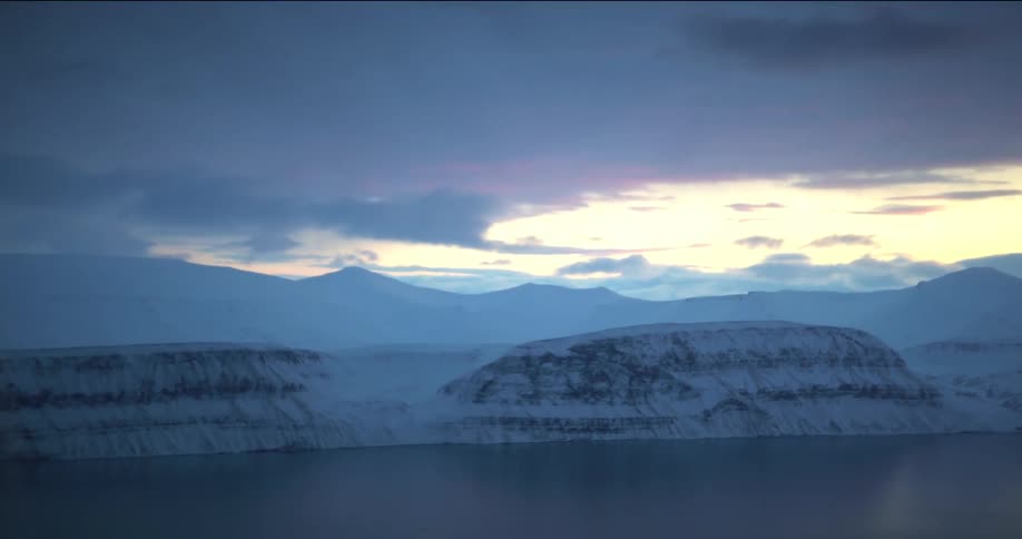 An aerial view of snowcovered mountains and a lake