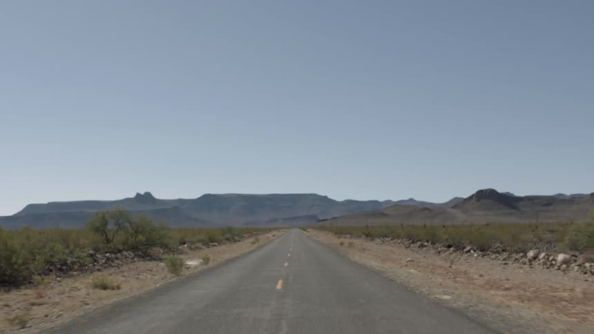 Moving down an empty road with a mountain in the distance