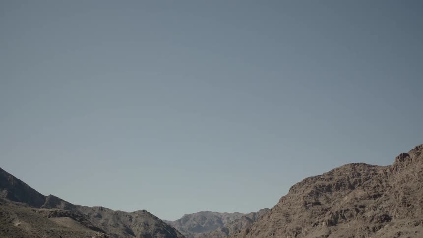 Desert mountains sit beneath a blue sky