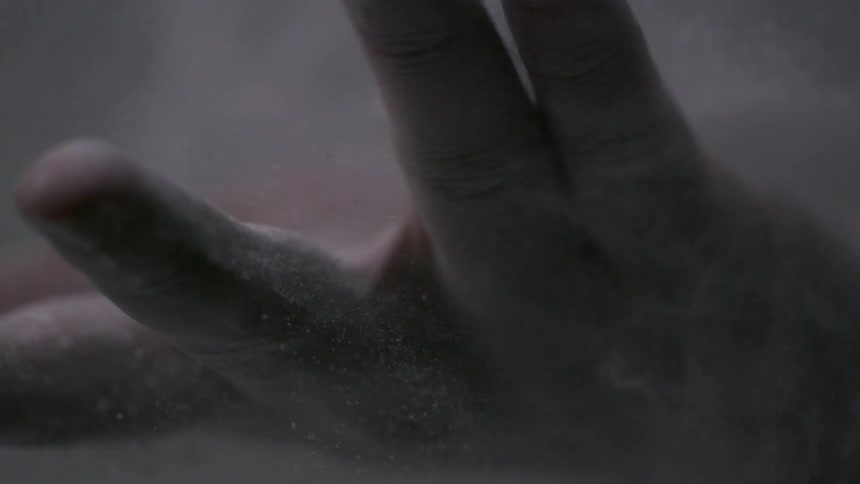 A man shakes sand off of his hand