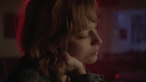 A woman sitting at a bar flirts and smiles