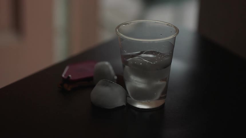 A glass of ice water sits on a table