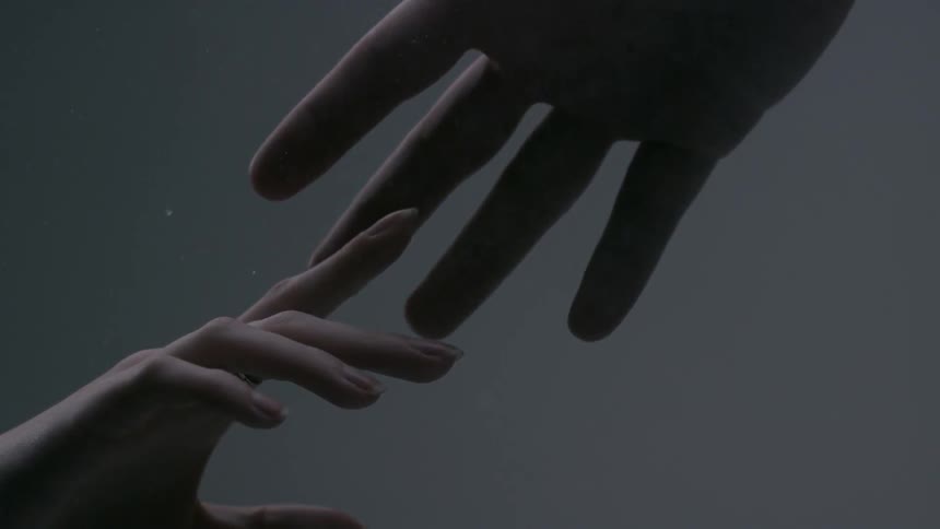 A male hand is reaching out to a female hand