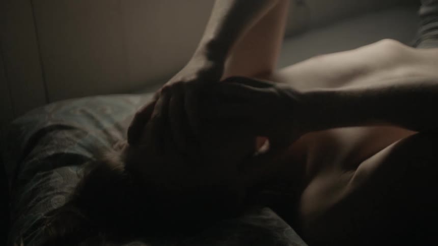 Man lays in bed with his hands over his face
