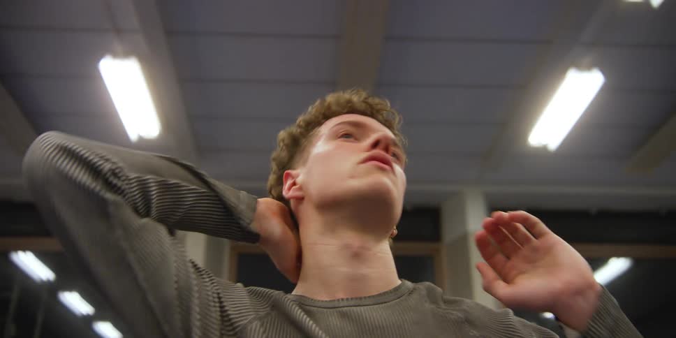 A man is brushing his hair back