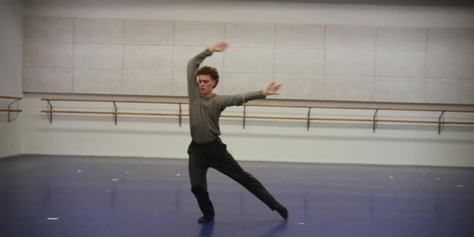 A boy dancing in an empty dance room
