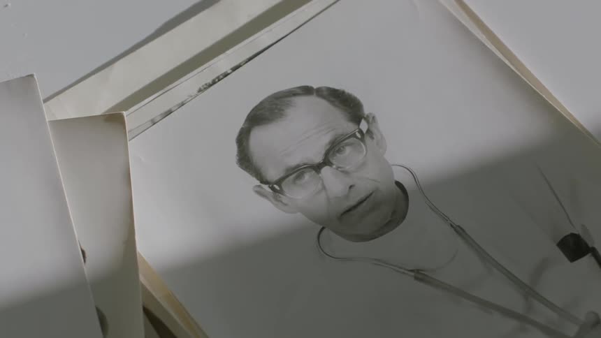 A black and white photograph of a doctor sits on a tabletop