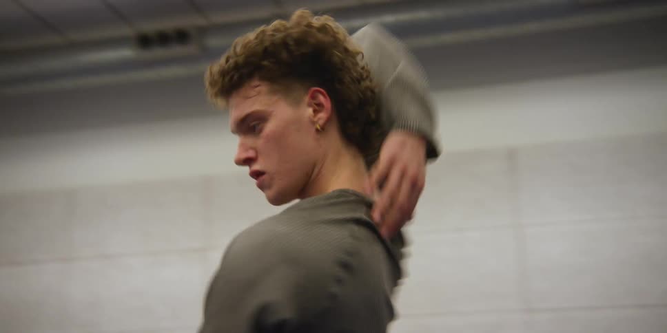 Man in a room performing his art while dancing