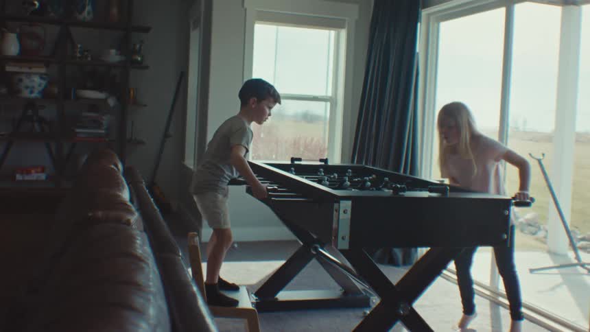 A boy and a girl play table football