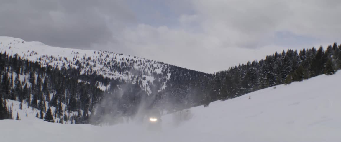 A snowmobile moves over heavy snow