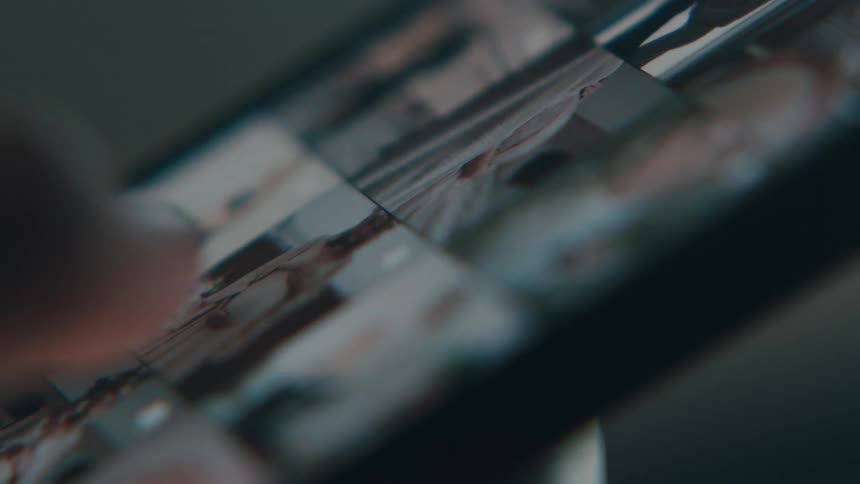 A hand scrolling through photos and the photo gallery on a smart phone