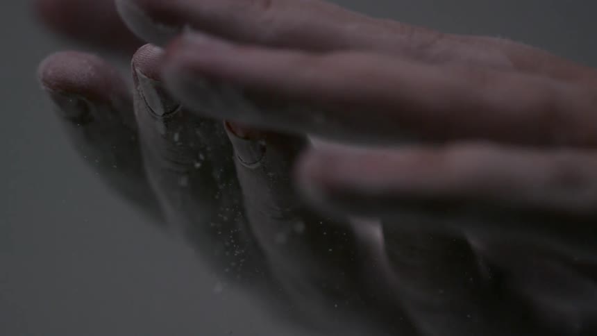 A hand is dusting powder off another hand
