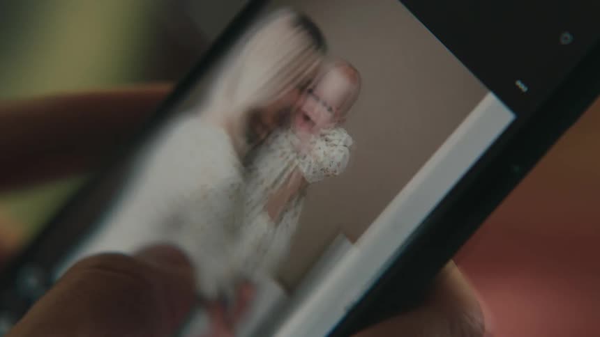 A person swipes through various photos on a phone