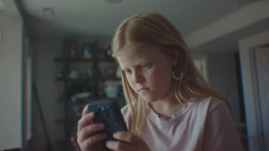 A concentrated girl using a cell phone