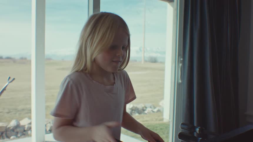 A young girl plays foosball inside a house
