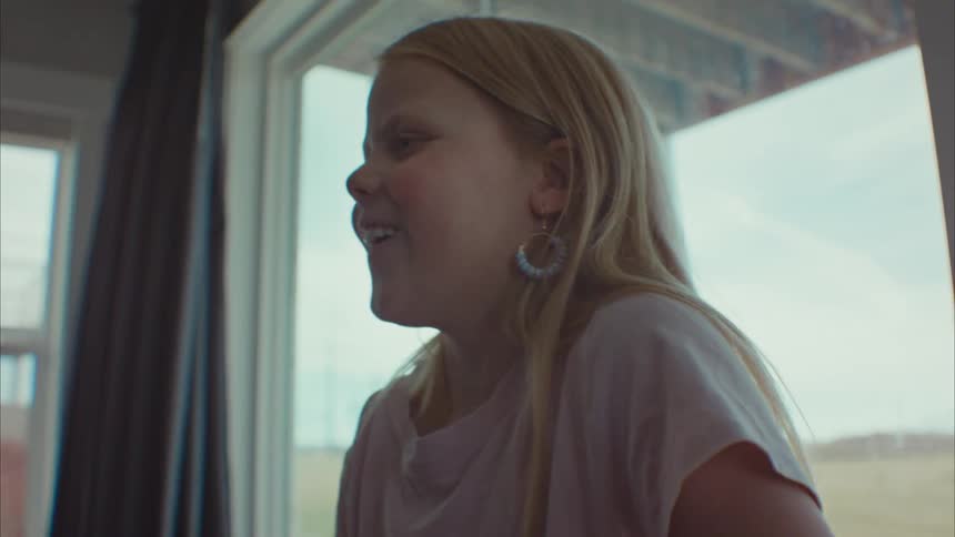 Portrait of a blonde girl in a room having fun while playing