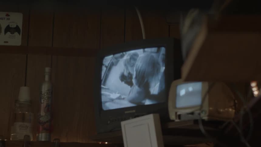 Two people are shown kissing on a television