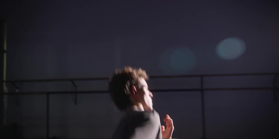 Young man in a room with low lighting dancing