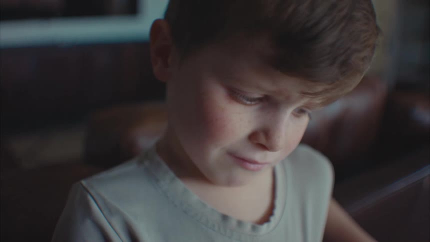A young boy makes a sad face