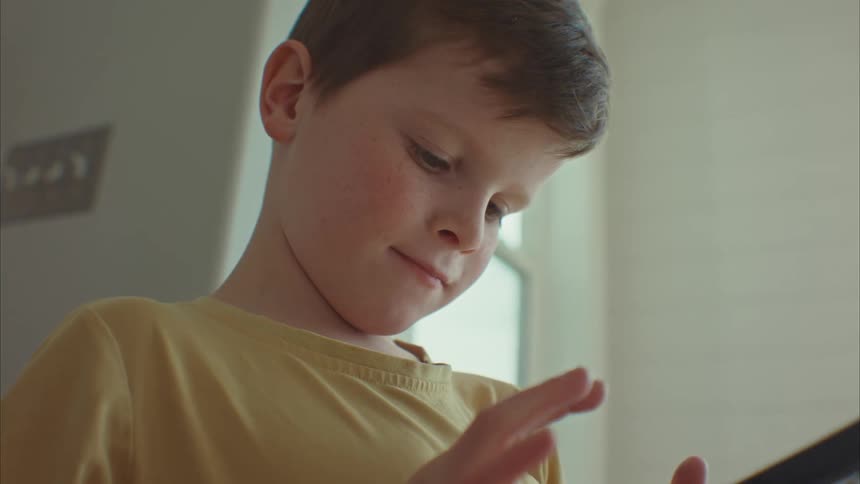 Closeup of a happy boys face using a cell phone