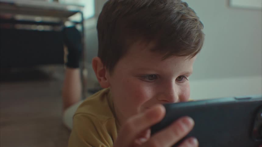 Closeup of a boys face playing on his cell phone