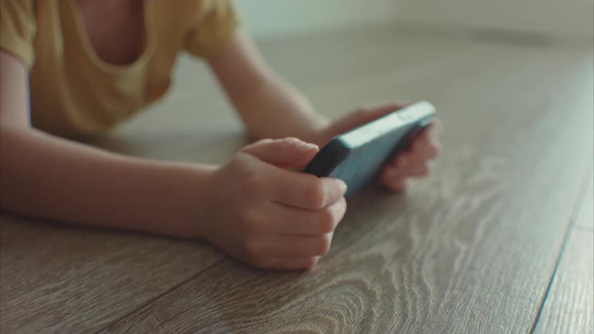 A young girl uses a smartphone