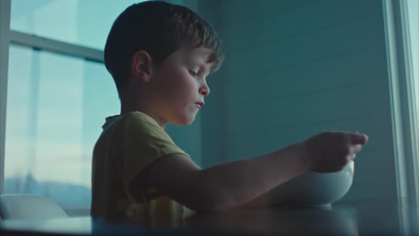 Boy sitting at the table eating cereal