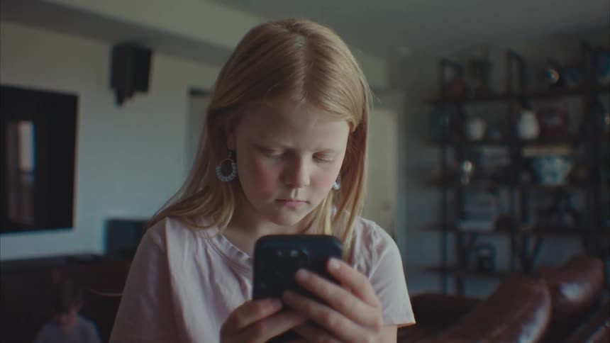 Portrait of a little girl playing with an iphone