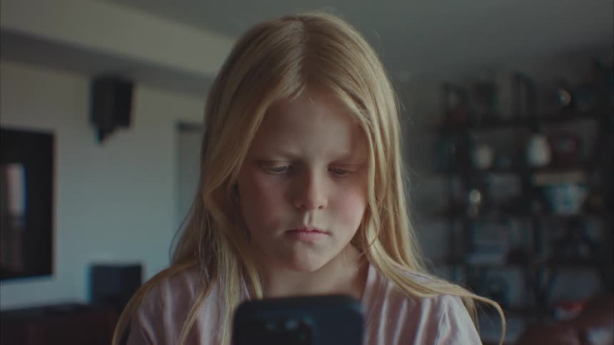 A girl is looking at her cell phone at home