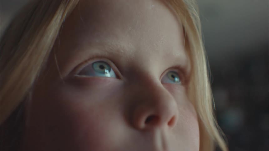 A young girl rolls her eyes upwards and stares