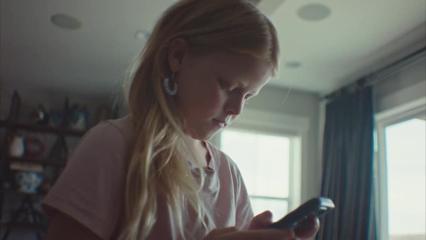 A clip of a girl operating her smartphone in a room