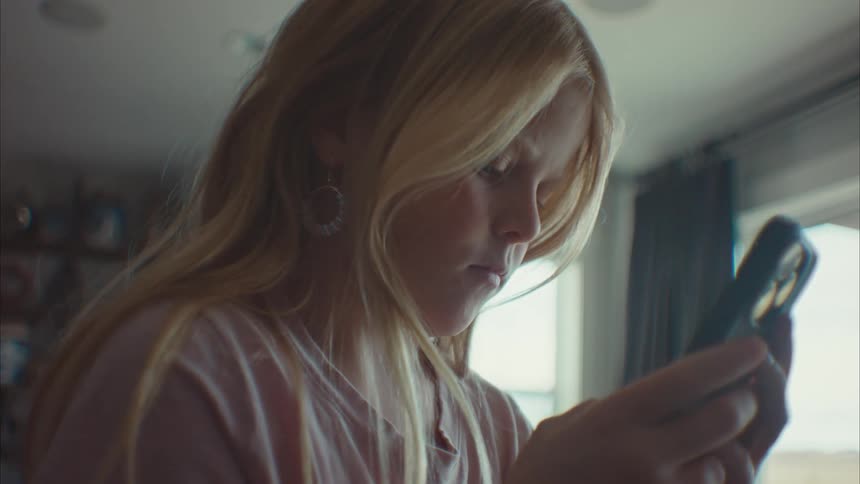A clip of a girl operating a smartphone in the room