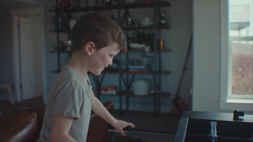 Little boy playing and having fun on a foosball table