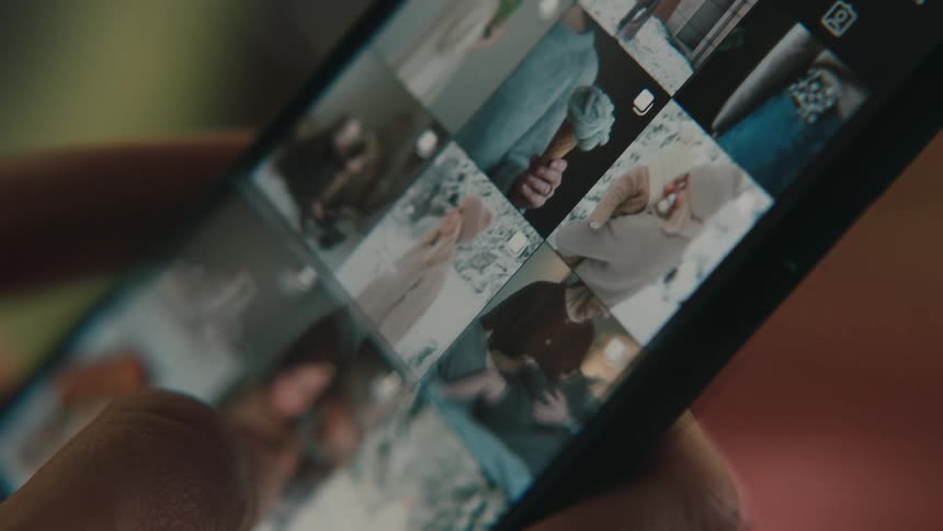 Hand of a person scrolling through images on a smartphone