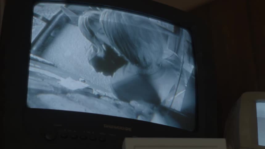A woman and man kissing can be seen in a surveillance monitor