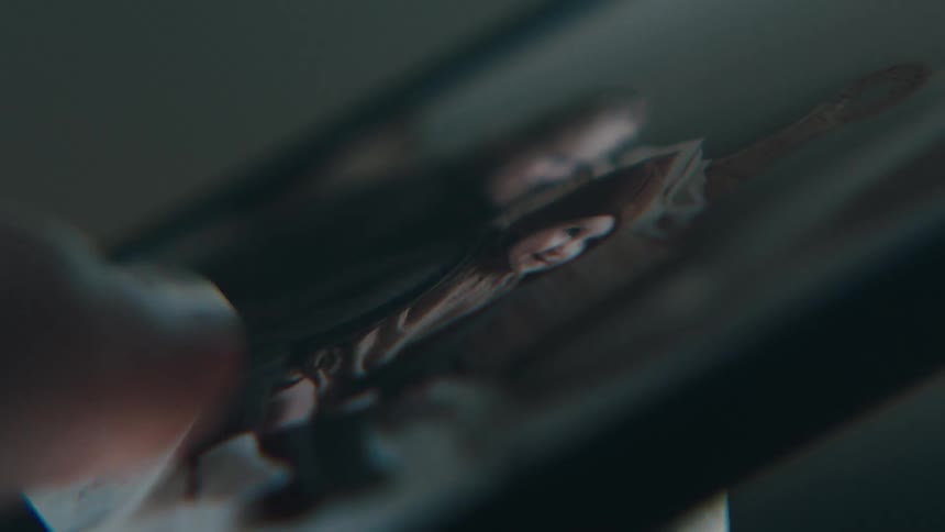 Extreme closeup on a cell phone screen with a persons finger moving while viewing photos