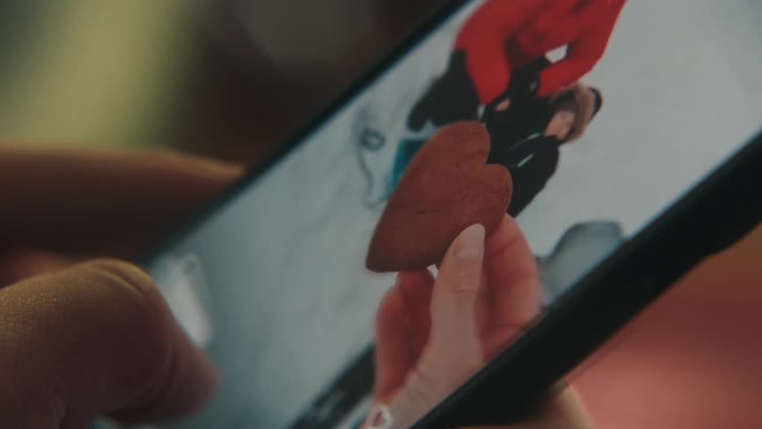 Someone holding a smart phone and watching a video montage of a winter family vacation
