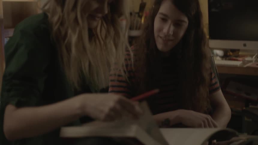 A man and a woman skim through a book