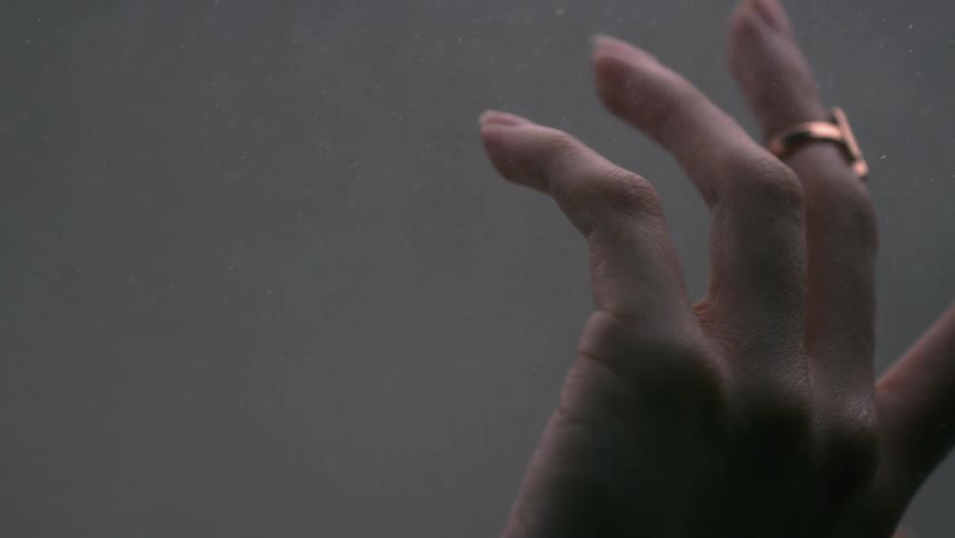 Dust falls around a woman's hand