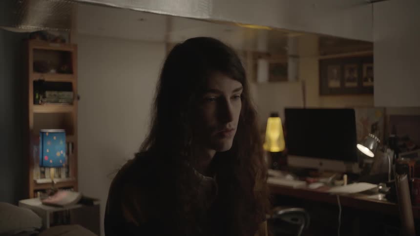 A woman is standing in the middle of a bedroom