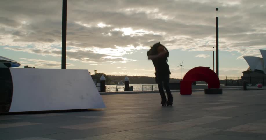 Skater takes jump off ramp at waterfront near sydney opera house