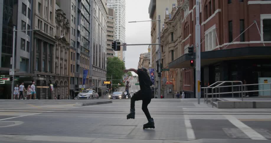 Man roller skates through city streets near public transit train