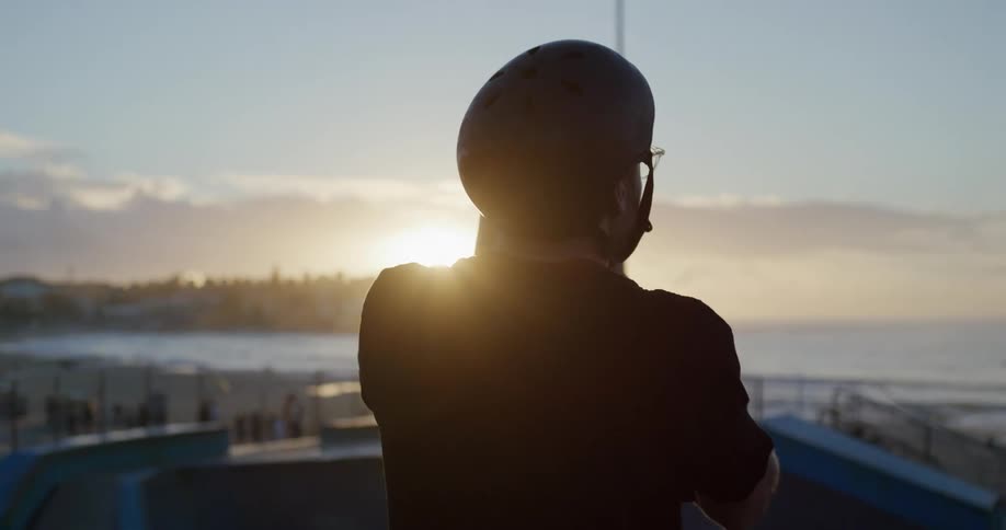 A man from behind put a helmet on his head