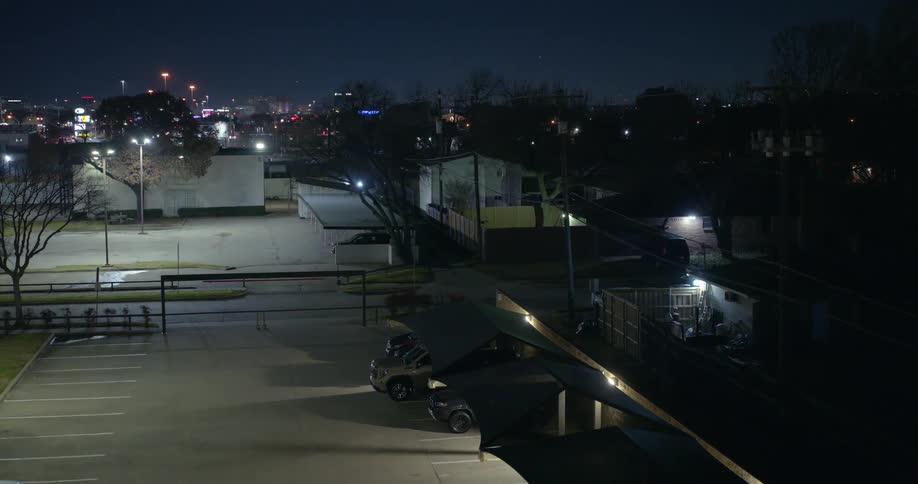 Aerial of a parking lot in a quiet neighborhood at night