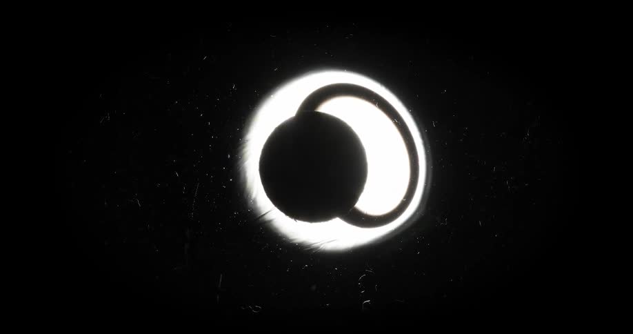 Dark ring moves past black sphere in glowing portion of liquid